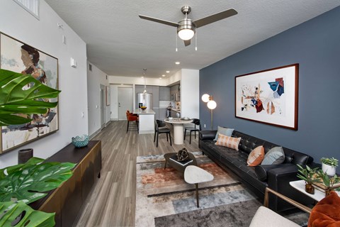 a living room with a couch and a table and a ceiling fan